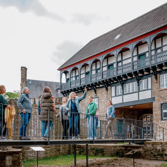 Gruppe mit Tourguide bei einer Führung über den Erlebnispfad im Schloß Broich