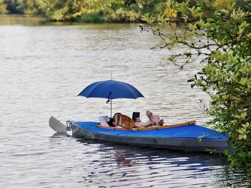 Mann entspannt auf einem Kanu im Sommer in Mülheim an der Ruhr