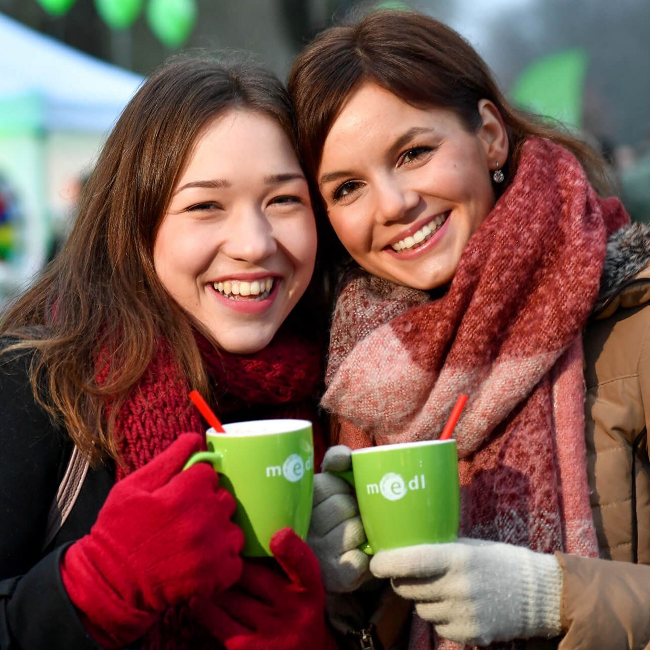 Freundinnen mit medl-Tassen beim medl-Winter-Grillen im Stadthallengarten