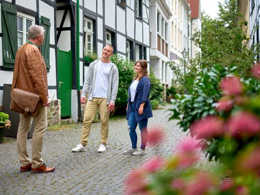 Paar und Tourguide auf Stadtführung im Sommer durch die Mülheimer Altstadt