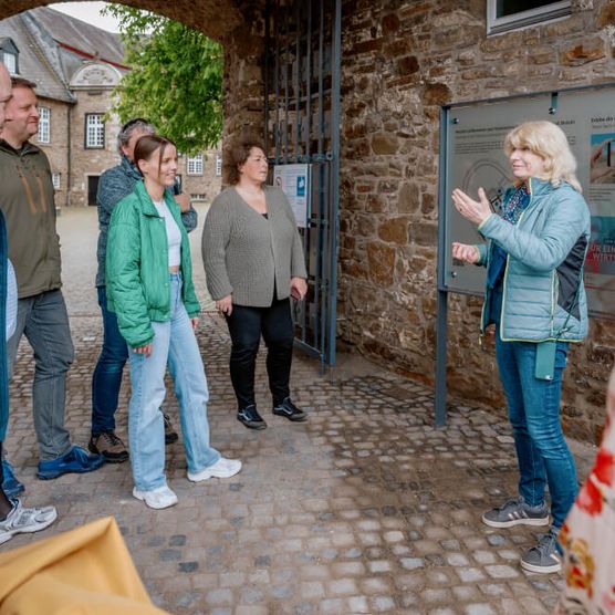 Gruppe mit Tourguide auf dem Erlebnispfad im Schloß Broich