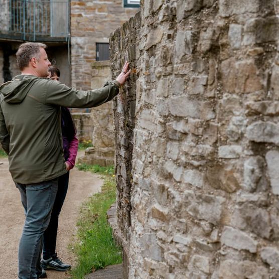 Paar an einer Mauer auf dem Erlebnispfad im Schloß Broich