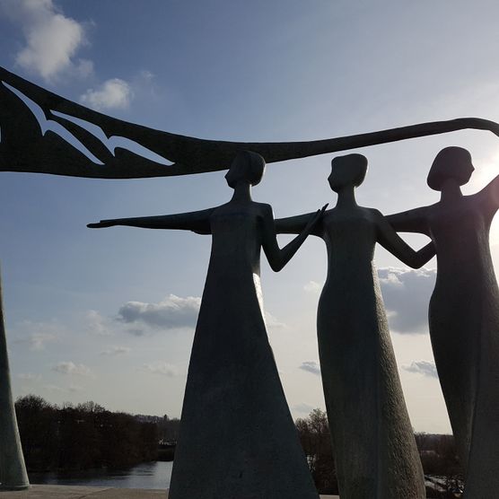 Statue „Die drei Grazien” bei Sonnenuntergang auf der Schloßbrücke in Mülheim