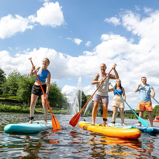 Gruppe steht auf SUPs im Sommer am Stadthafen Mülheim