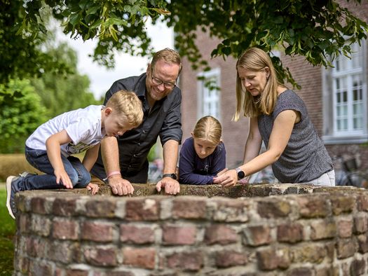 Familie an einem Brunnen im Sommer im Kloster Saarn