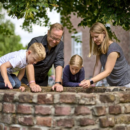 Familie an einem Brunnen im Sommer im Kloster Saarn